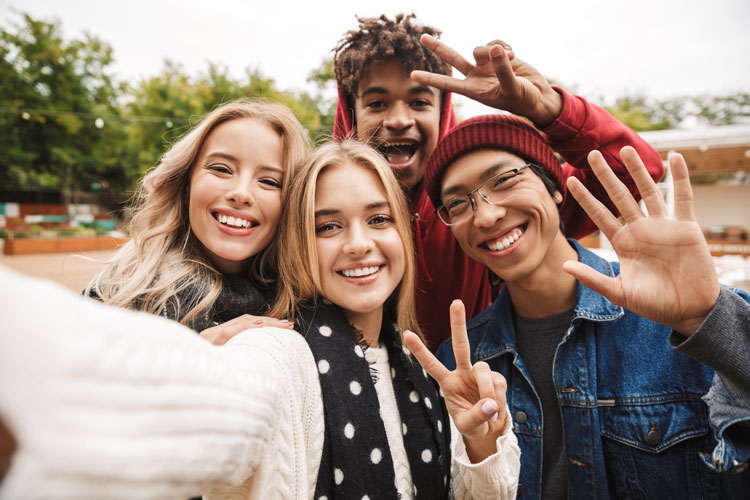 4 Teenanger lachen in die Kamera